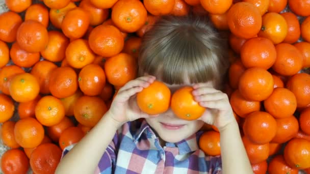 Enfant heureux couché dans les oranges . — Video