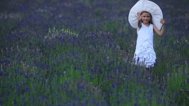 Дівчина стоїть у фіолетових квітах . — стокове відео
