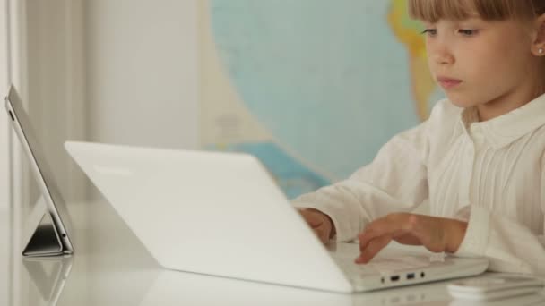 Dziewczyna siedzi w tabela przy użyciu laptopa — Wideo stockowe