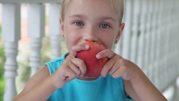 Chica comiendo un melocotón rojo grande — Vídeos de Stock