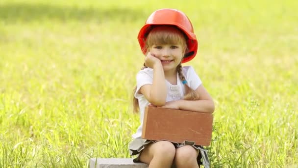 Girl  sits on cinder block. — Stock Video