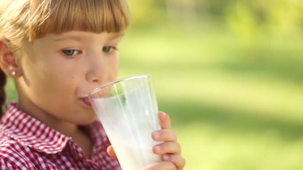Улыбающаяся девушка пьет молоко — стоковое видео