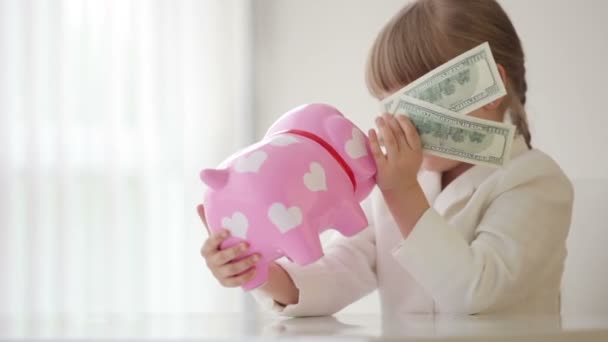 Businesswoman sitting with a piggy bank — Stock Video