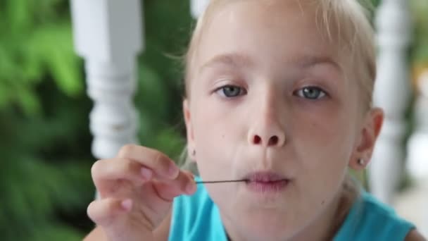 Menina colocando uma grande cereja em sua boca — Vídeo de Stock