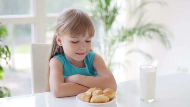 Schattig klein meisje zit aan tafel — Stockvideo