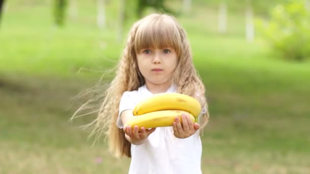 Flickan bjuder in betraktaren en bananer — Stockvideo