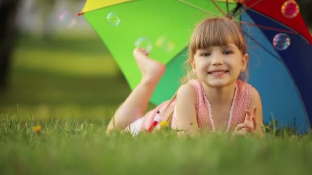 Дитина лежить на траві — стокове відео