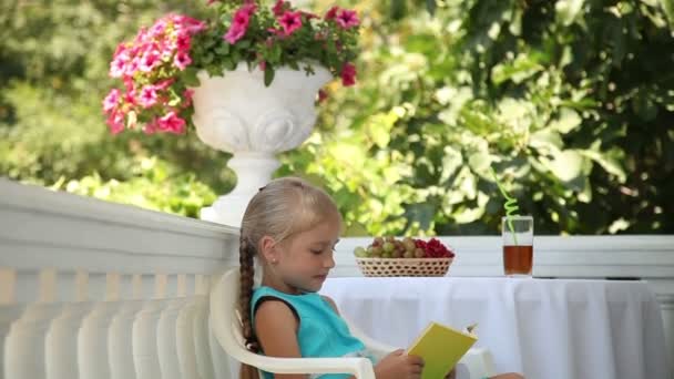 Förskolebarn tjej läser en bok — Stockvideo