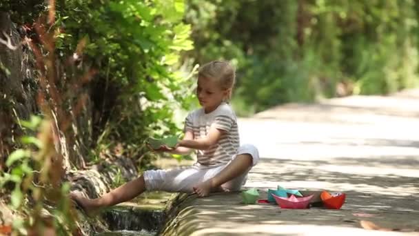 Enfant jouant avec des bateaux jouets — Video