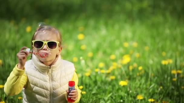 Kleines Mädchen pustet Seifenblasen — Stockvideo