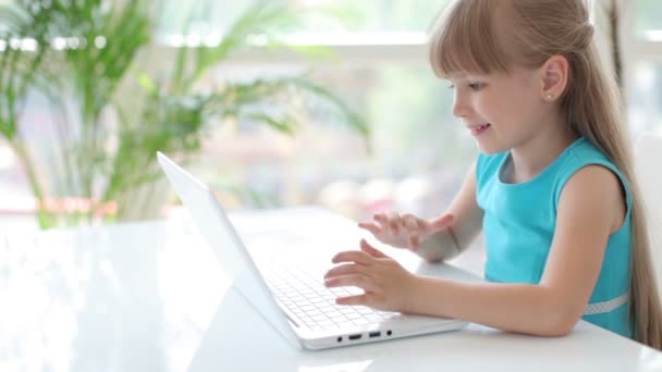 Девушка сидит за столом с помощью ноутбука — стоковое видео