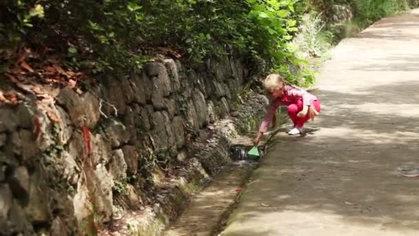 Dívka, zahájení spoustu papírových lodiček — Stock video