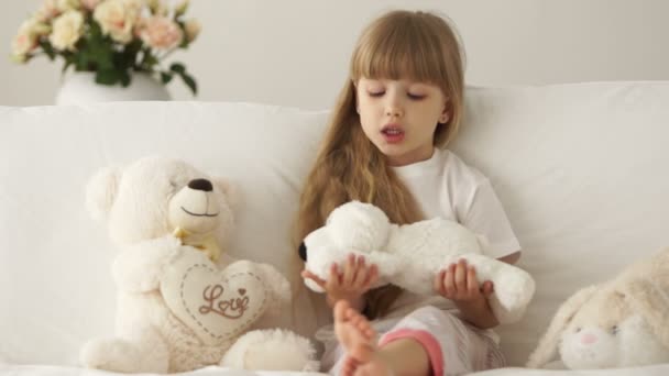 Cute little girl sitting on sofa — Stock Video