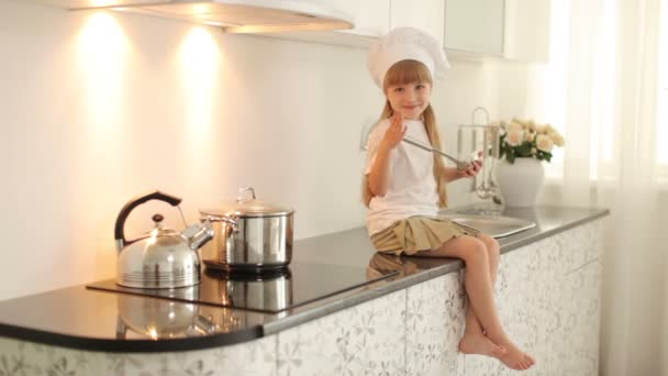 Menina sentada na cozinha — Vídeo de Stock