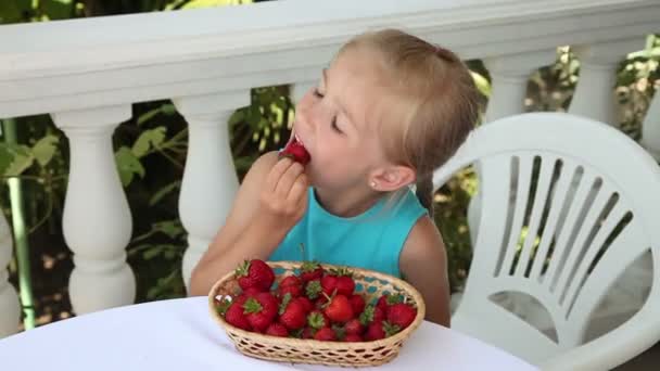 Klein meisje dat aardbeien eet — Stockvideo