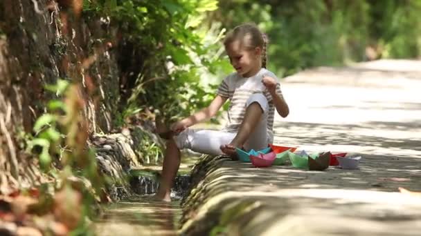 Chica lanzando un montón de barcos de papel — Vídeo de stock