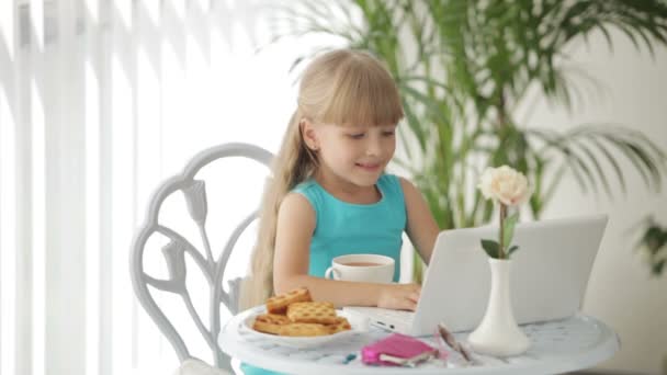 Lustiges kleines Mädchen sitzt am Tisch — Stockvideo