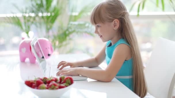 Meisje zitten aan tafel met behulp van laptop — Stockvideo