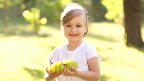 Happy little girl holding grapes — Stock Video