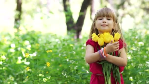 小さな女の子が花束を抱いて — ストック動画