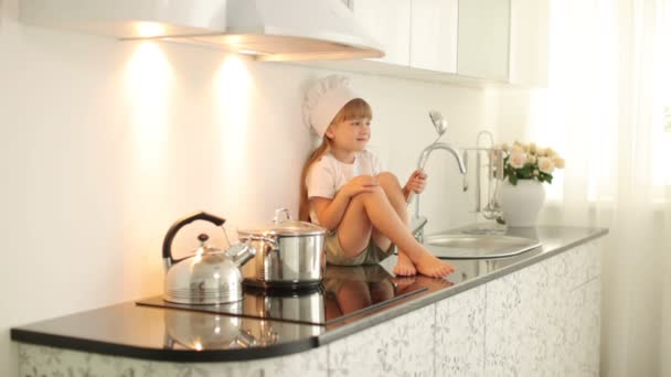 Little girl sitting with a ladle — Stock Video