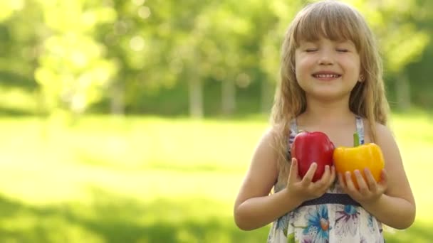 Kind umarmt zwei Gemüsepaprika — Stockvideo