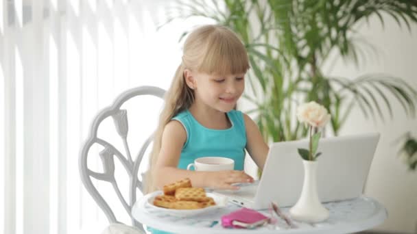 Κορίτσι κάθεται στο τραπέζι με φορητό υπολογιστή — Αρχείο Βίντεο