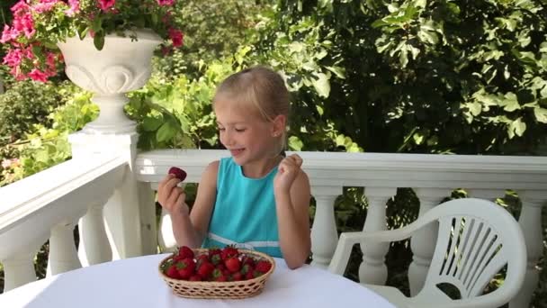 Meisje dat aardbeien eet in de tuin. — Stockvideo