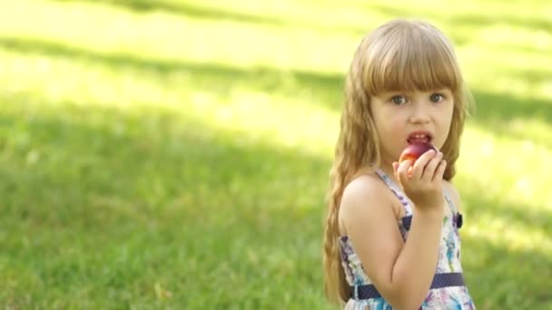 Dziewczynka jedzenie brzoskwinia. — Wideo stockowe