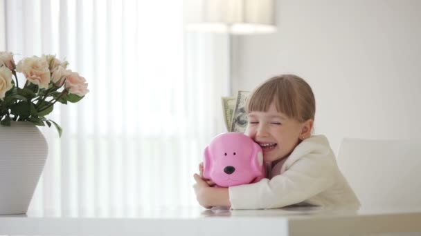 Little girl hugging a piggy bank — Stock Video