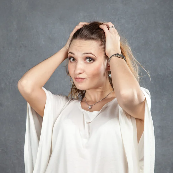 Mulher perplexa com as mãos no cabelo — Fotografia de Stock