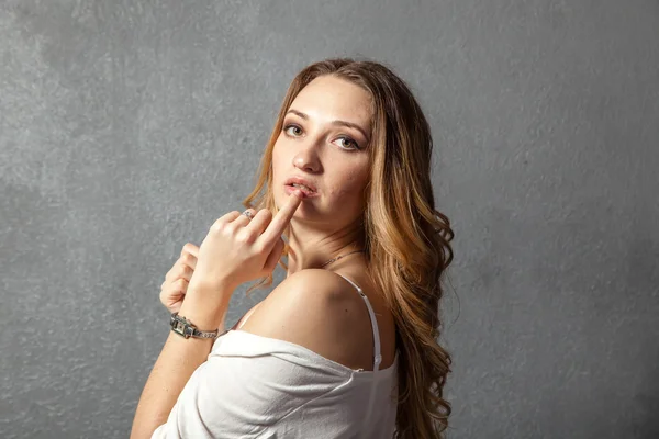 Attractive young woman with finger on lips — Stock Photo, Image