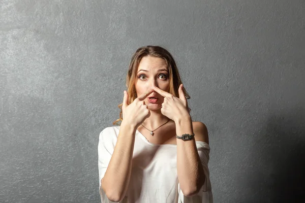 Young woman pointing at her nose with fingers — Stock Photo, Image