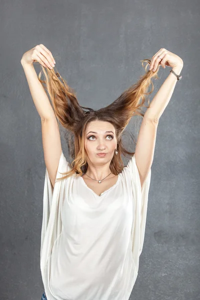 Casual young woman plaing with hair — Stock Photo, Image