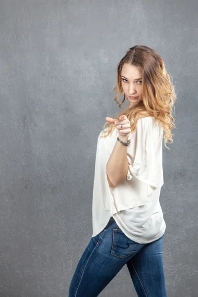 Casual young woman pointing at camera with finger — Stock Photo, Image