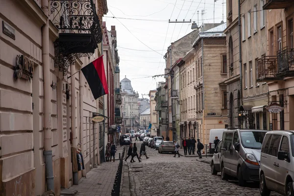 Львов, Украина - 23 февраля 2015 года Узкая улица Львова с боевым украинским флагом — стоковое фото