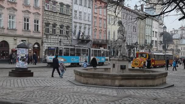 LVIV, UCRÂNIA - 28 de fevereiro de 2015 Praça central de Lviv ocupada com pedestres andando e passeios de bonde — Vídeo de Stock