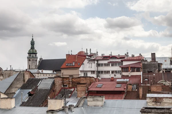 Wysoka wieża wśród starych dachów, Lwów — Zdjęcie stockowe