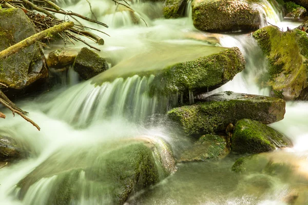 Cascading waterfall closeup very smooth water with wet rocks — Stock Photo, Image