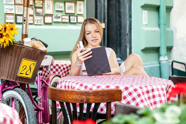 yaz terasında oturup ve kitap okuma kız gülümseyerek