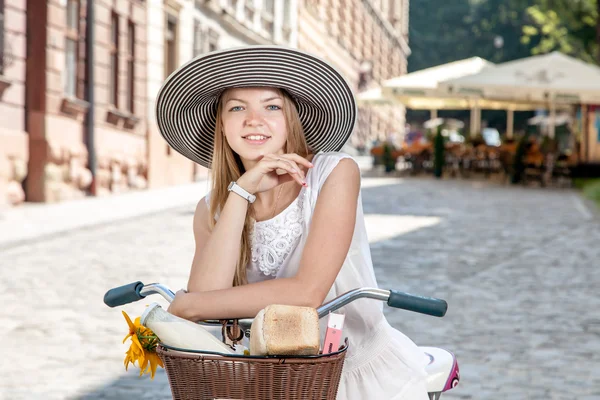 Women on pink bicycle with grocery basket posing in street — Stock Photo, Image