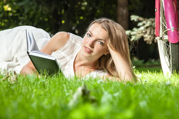 Vrouw legt leesboek in stadspark — Stockfoto