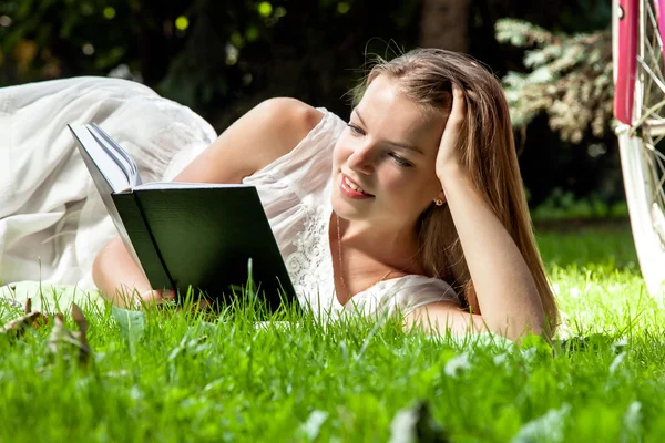 Mujer pone libro de lectura en el parque de la ciudad —  Fotos de Stock