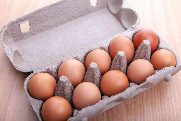 Ovos castanhos em caixa de ovo na mesa da cozinha — Fotografia de Stock