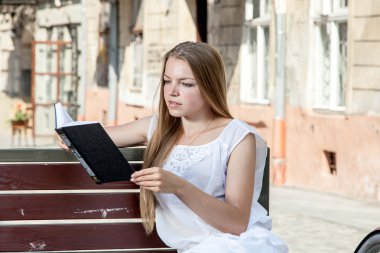 bankta oturan ve kitap okuma bisiklet ile kız
