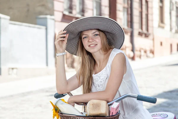 Women on pink bicycle with grocery basket posing in street — Stock Photo, Image