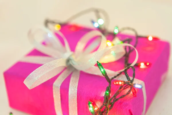 Weihnachtsbeleuchtung und verpacktes Geschenk — Stockfoto
