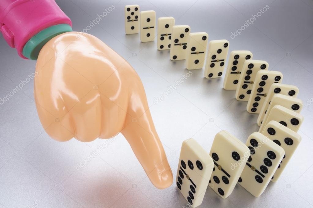 Plastic Hand and Row of Dominoes
