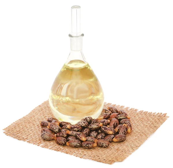 Castor oil with beans on sack — Stock Photo, Image