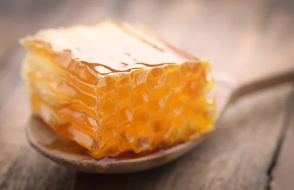 Honeycomb in a wooden spoon — Stock Photo, Image